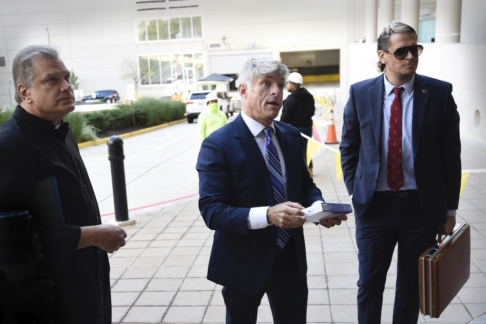 Fr. Paul Kalchik, left, St. Michael’s Media founder and CEO Michael Voris, center, and Milo Yiannopoulos talk with a court officer before entering the federal courthouse Sept. 30 in Baltimore. (AP photo/Gail Burton, file)