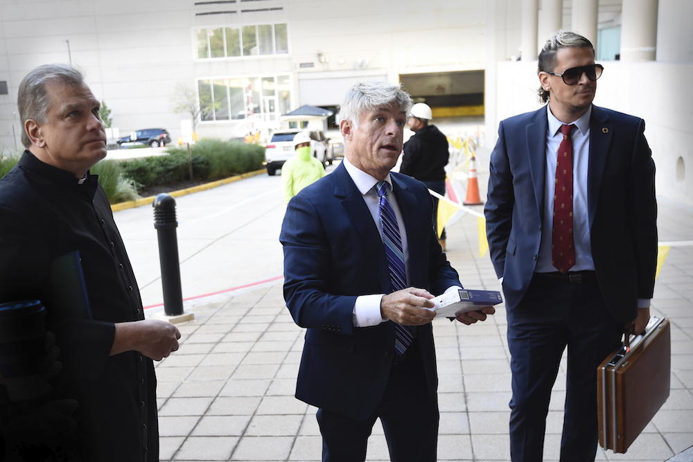 Fr. Paul Kalchik, left, St. Michael’s Media founder and CEO Michael Voris, center, and Milo Yiannopoulos talk with a court officer before entering the federal courthouse Sept. 30 in Baltimore. (AP photo/Gail Burton, file) Fr. Paul Kalchik, left, St. Michael’s Media founder and CEO Michael Voris, center, and Milo Yiannopoulos talk with a court officer before entering the federal courthouse Sept. 30 in Baltimore. (AP photo/Gail Burton, file)