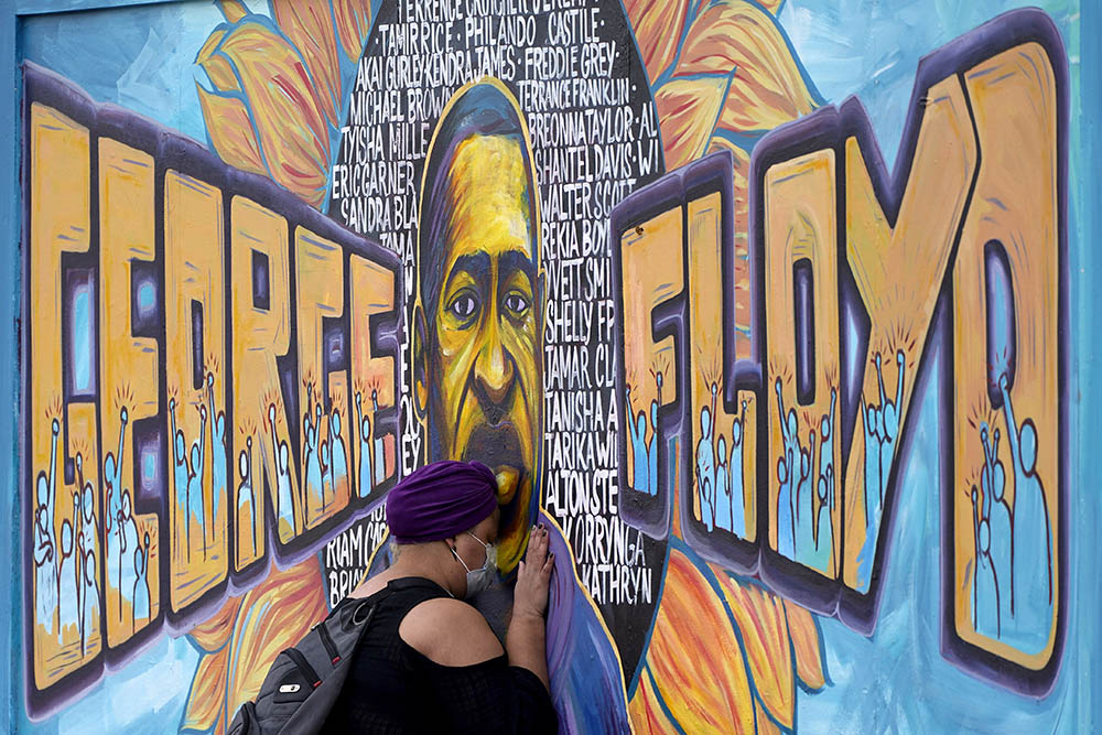 Damarra Atkins pays her respects to George Floyd at a mural at George Floyd Square April 23 in Minneapolis. (AP Photo/Julio Cortez)