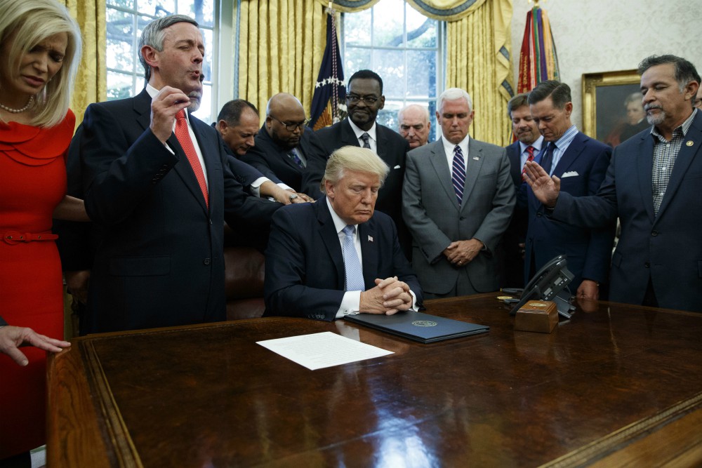 On Sept. 1, 2017, religious leaders pray with President Donald Trump in the Oval Office of the White House in Washington after he signed a proclamation for a National Day of Prayer to occur on Sunday, Sept. 3, 2017. (AP Photo/Evan Vucci)