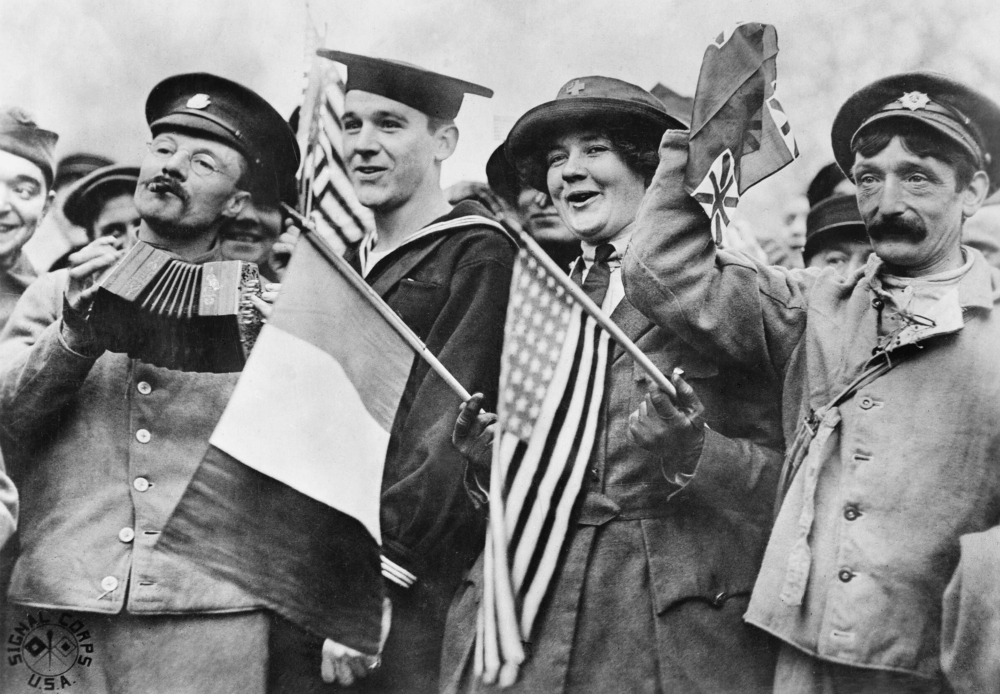 An American sailor, an American Red Cross nurse and two British soldiers celebrate the signing of the Armistice, near the Paris Gate at Vincennes, France, Nov. 11, 1918. (Wikimedia Commons/Imperial War Museum) An American sailor, an American Red Cross nurse and two British soldiers celebrate the signing of the Armistice, near the Paris Gate at Vincennes, France, Nov. 11, 1918. (Wikimedia Commons/Imperial War Museum)