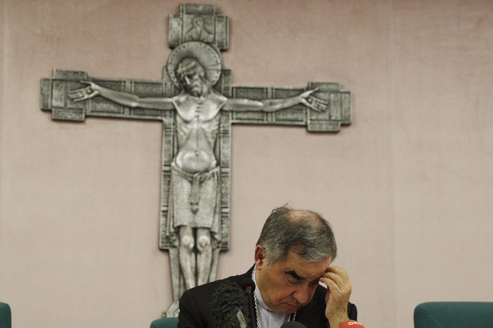 Cardinal Angelo Becciu looks down as he meets the media during a news conference in Rome