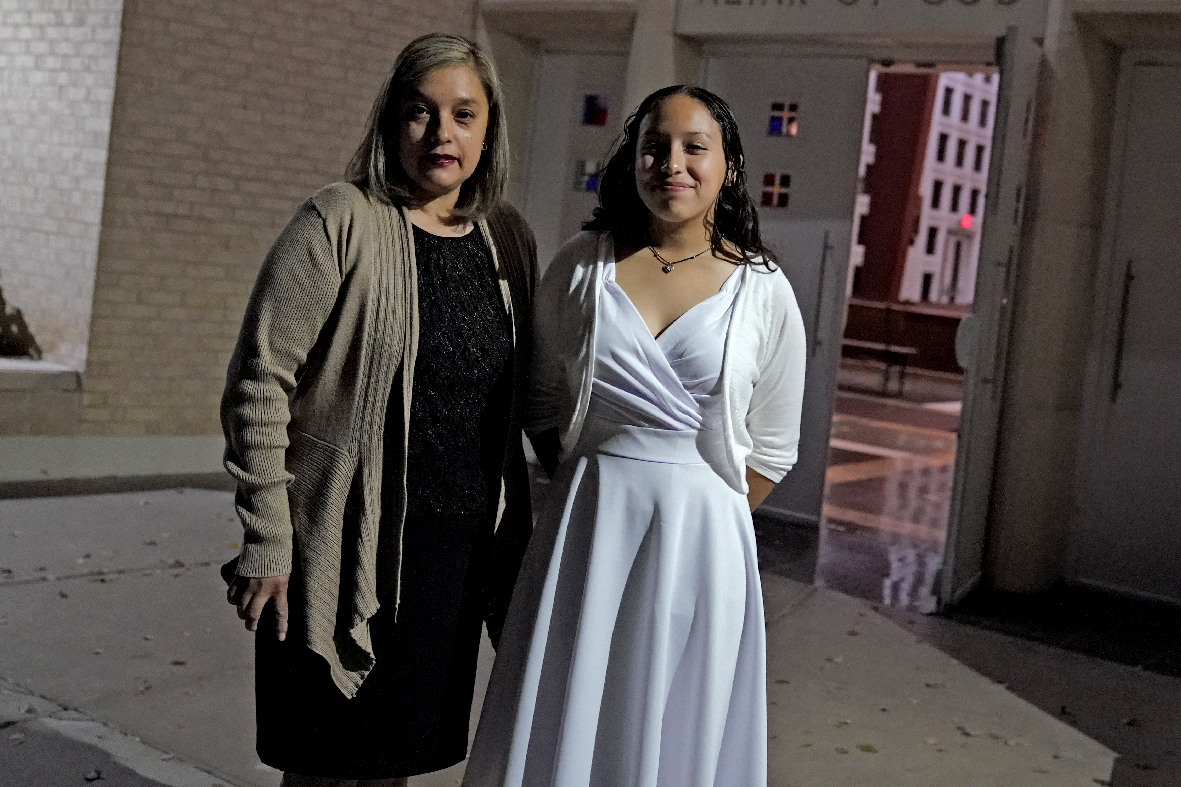 Parishioners Eliana Najera and her daughter, Alysson Najera, 13, stop for a photograph as they leave St. Gregory Catholic Church, Phoenix, AZ , Feb. 24, 2022. (AP Photo/Matt York)