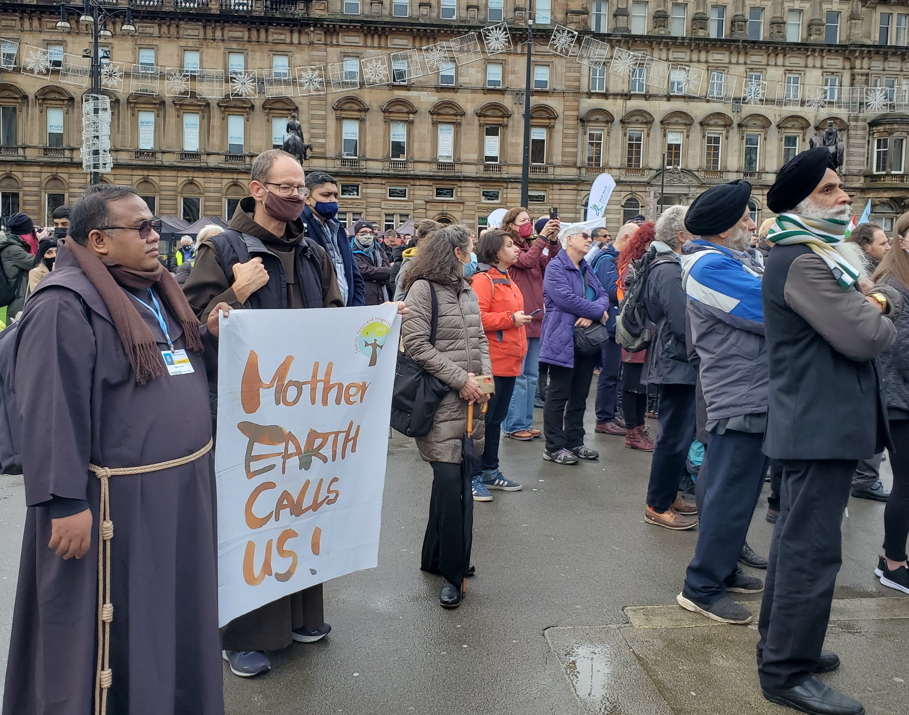 Br. Angel Cortez, left, listens during the multifaith service Oct. 31. He said he traveled to COP26 in Glasgow to bring the voices of fellow Filipinos who were struck by three major typhoons amid the COVID-19 pandemic in 2020. (NCR/Brian Roewe)