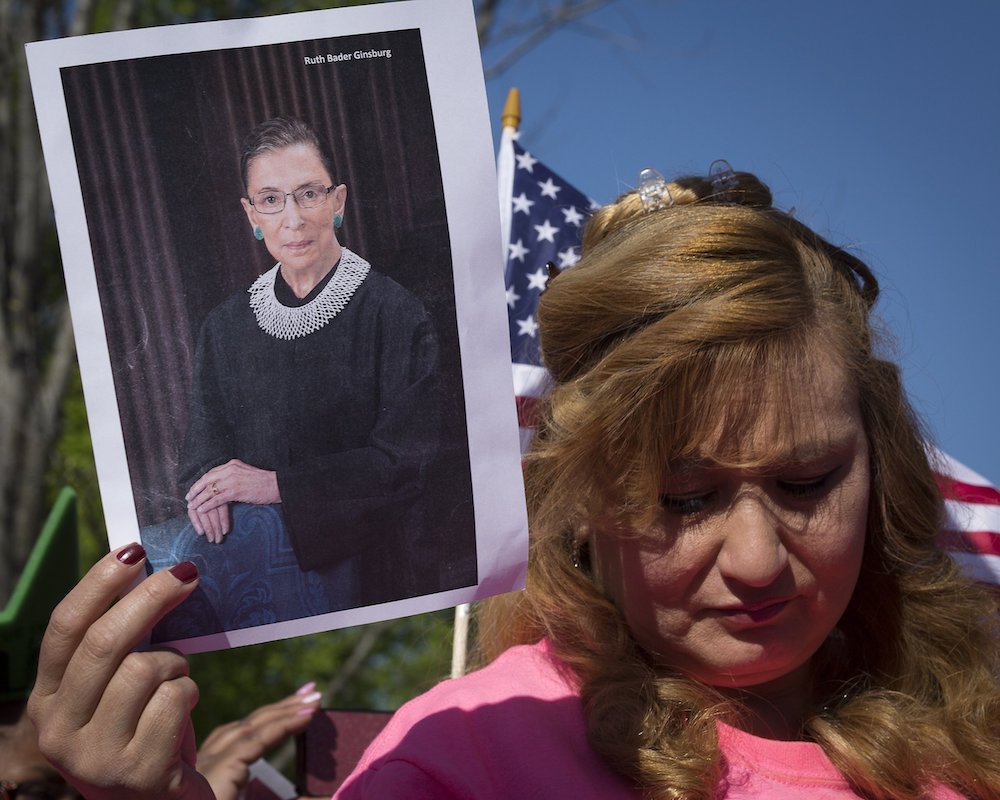 A demonstrator at a Deferred Action for Childhood Arrivals rally holds a photo of Justice Ruth Bader Ginsburg while standing outside the U.S. Supreme Court in Washington in 2016. (CNS/Tyler Orsburn)