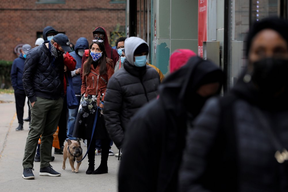 U.S. Rep. Alexandria Ocasio-Cortez, glasses on head, stands in line to vote in the Bronx borough of New York City Oct. 25. (CNS/Reuters/Andrew Kelly)