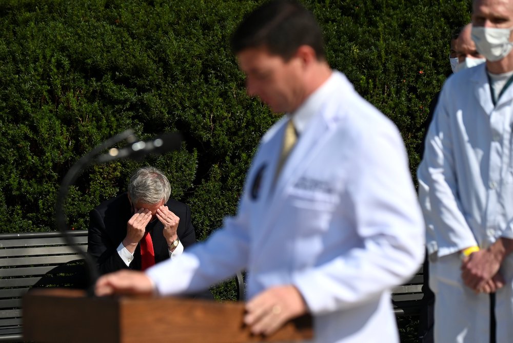 White House Chief of Staff Mark Meadows, left, sits outside Walter Reed National Military Medical Center in Bethesda, Maryland, Oct. 4, as Dr. Sean Conley, a Navy commander who is the White House physician, speaks to the media about President Donald Trump