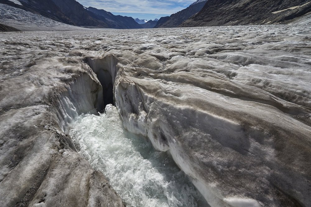 Water runs through a hole in the melting Aletsch Glacier in the Swiss Alps. (CNS/Reuters/Denis Balibouse)