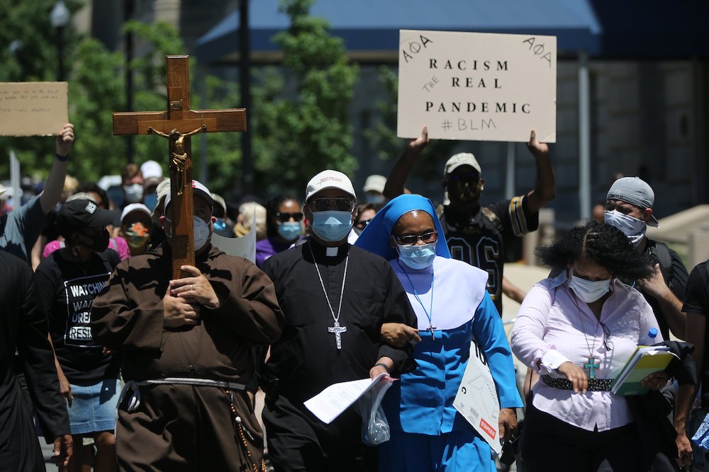 Washington Auxiliary Bishop Roy E. Campbell and a woman religious walk with others toward the National Museum of African American History and Culture during a peaceful protest June 8, following the death of George Floyd at the hands of Minneapolis police 
