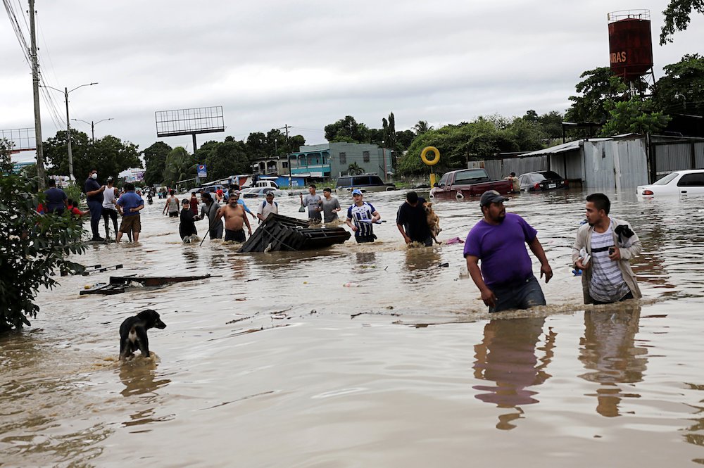 People wade through floodwaters in La Lima, Honduras, Nov. 5 in the rain-heavy remains of Hurricane Eta. (CNS/Reuters/Jorge Cabrera)