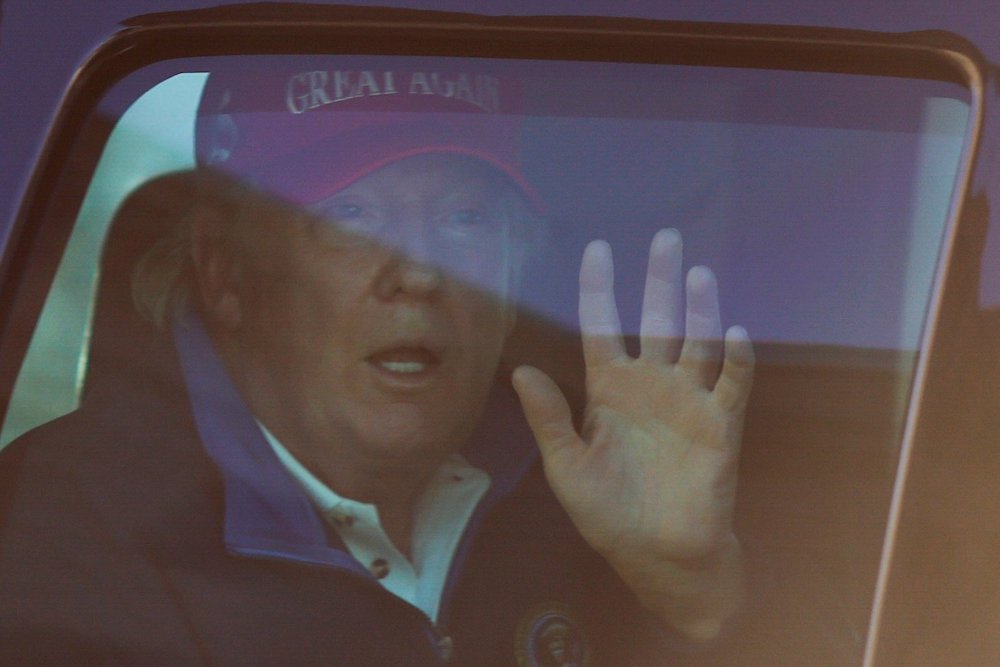 President Donald Trump waves to supporters in Washington Nov. 14, as he drives past Freedom Plaza upon his return from playing golf. (CNS/Reuters/Carlos Barria)