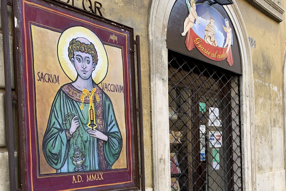 A poster of St. Stephen holding a "Holy Vaccine," by the Rome street artist known as Maupal, is seen near the Vatican Dec. 11. (CNS/Cindy Wooden)