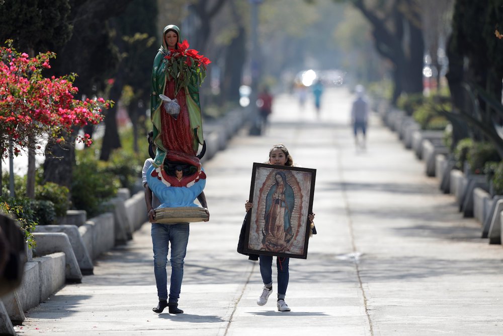 Pilgrims carry a statue and image of Our Lady of Guadalupe near the basilica in her name in Mexico City Dec. 12, 2020, during the COVID-19 pandemic. The basilica was closed that day to avoid crowds during Our Lady of Guadalupe feast day celebrations. (CNS