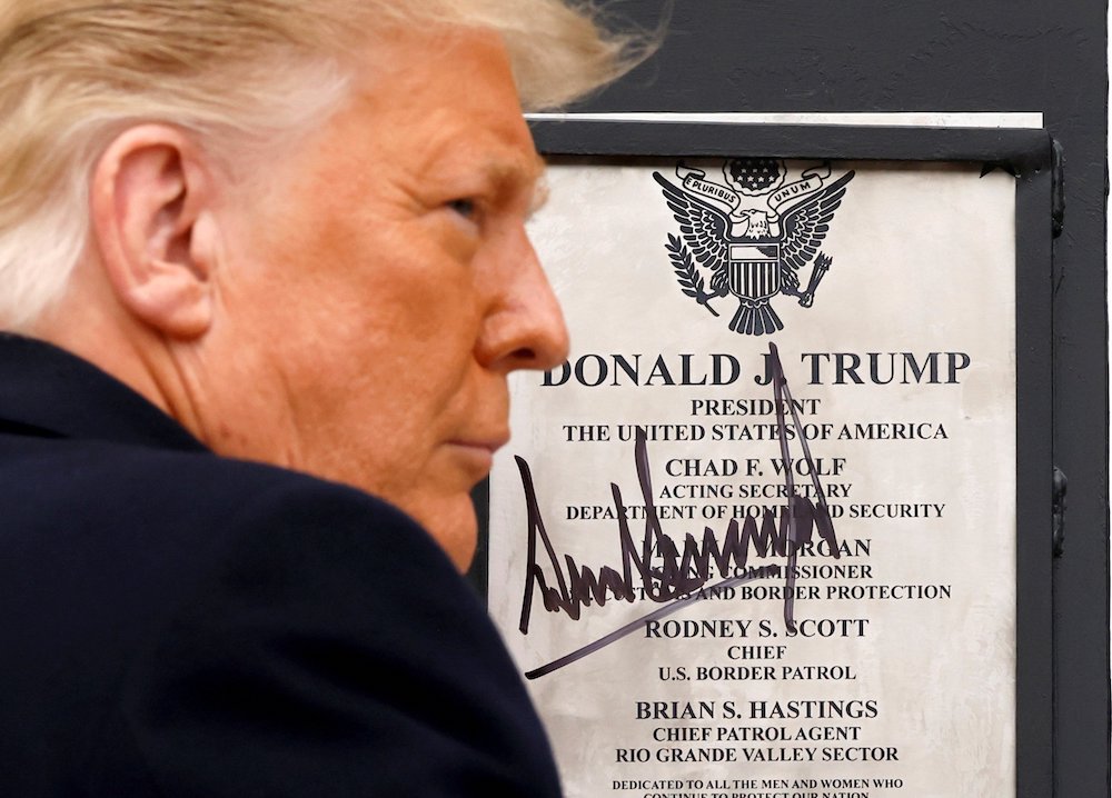President Donald Trump signs a plaque placed at the U.S.-Mexico border wall during his visit to Alamo, Texas, Jan. 12, 2021. (CNS/Reuters/Carlos Barria)