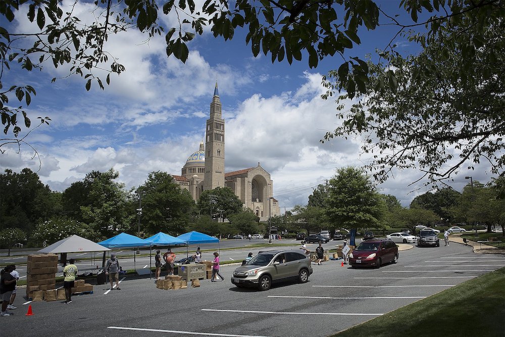 Catholic Charities staff and volunteers in the Archdiocese of Washington distribute 500 grocery boxes and 500 family meals in the parking lot of the Basilica of the National Shrine of the Immaculate Conception July 10, during the coronavirus pandemic. (CN