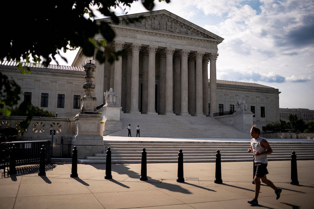 A person runs past the U.S. Supreme Court building in Washington June 25. (CNS/Reuters/Al Drago)