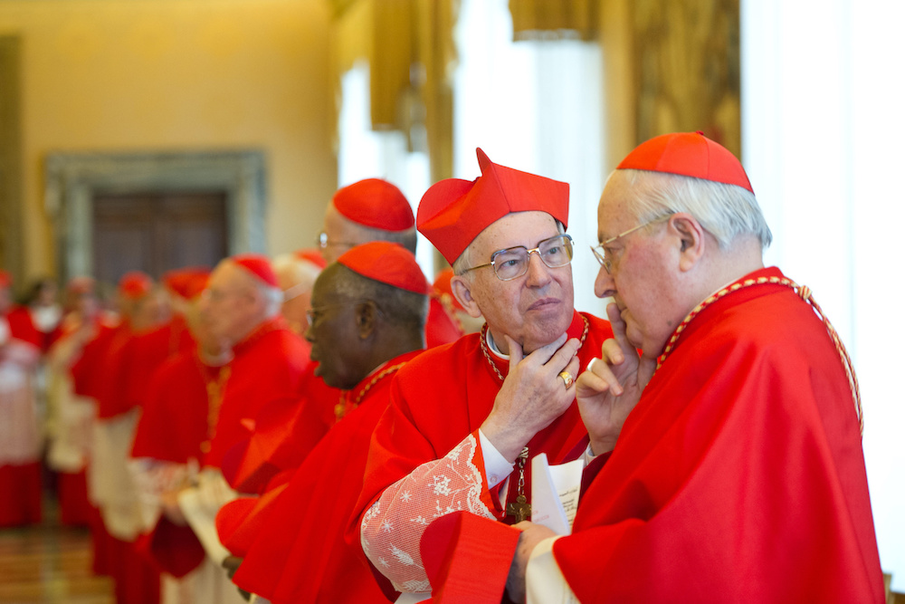 Cardinals Giovanni Battista Re and Angelo Sodano talk after Pope Benedict XVI announced his resignation in Latin during a meeting of cardinals at the Vatican, Feb. 11, 2013. (CNS/L'Osservatore Romano)