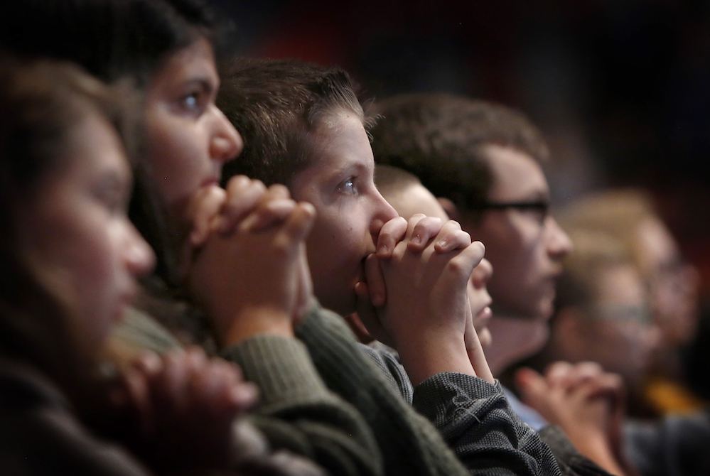 Students from St. Alphonsus/St. Patrick Catholic School in Lemont, Illinios, pray Oct. 19, 2019, during Holy Fire Chicago at the Credit Union 1 Arena. A new Pew Research Center study suggests most U.S. teens aged 13-17 identify with a religious faith and 
