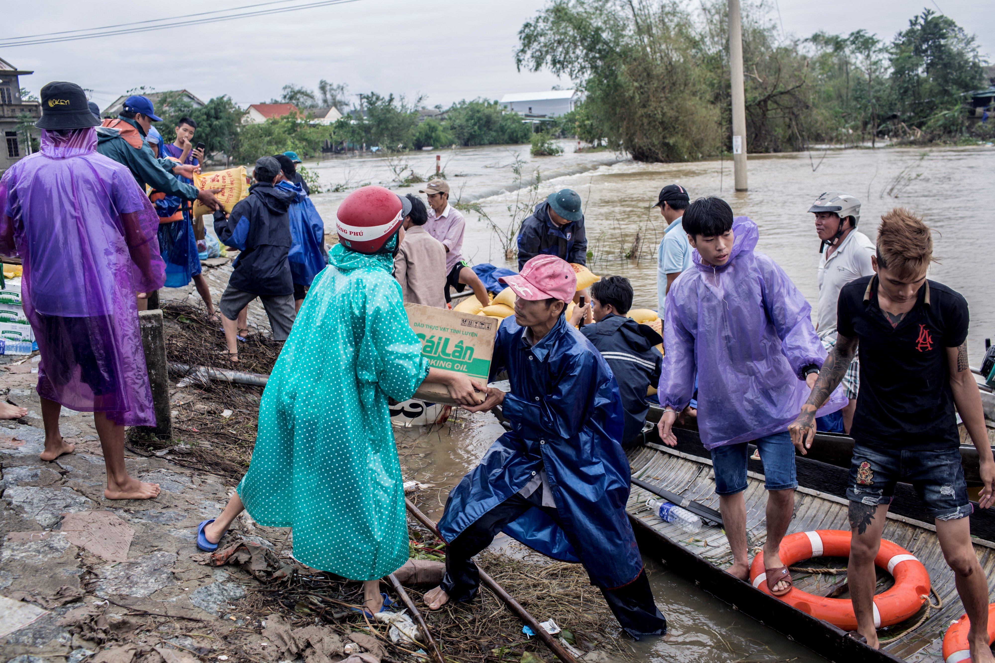Local residents and volunteers deliver aid packages to residents affected by flooding in Thua Thien Hue province, Vietnam, Oct. 20. (CNS/via Reuters/International Federation of the Red Cross handout/Yen Duong)