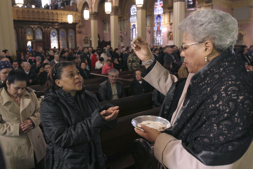 A eucharistic minister distributes Communion during Mass in 2018. According to Georgetown University's Center for Applied Research in the Apostolate, women perform the vast majority of lay ministries in their churches. (CNS/Gregory A. Shemitz) 