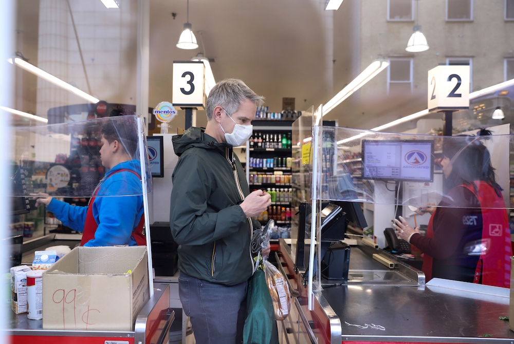 Grocery store check out March 28, 2020, shows pandemic precautions, masks and partitions. (CNS/Reuters/Caitlin Ochs)