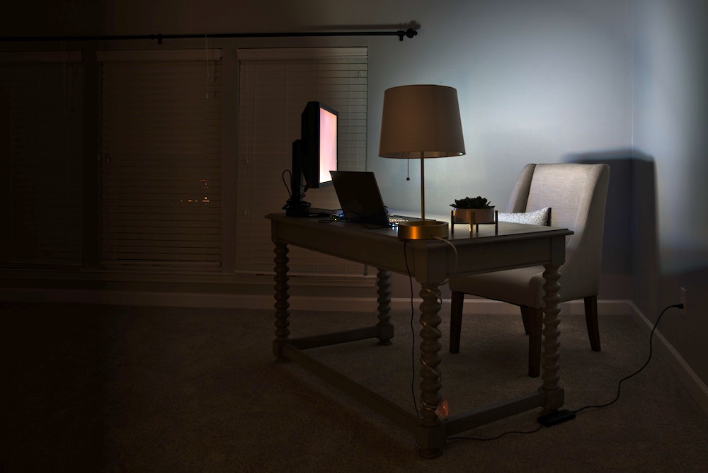 Photograph of a dimly lit room with desk and computer.