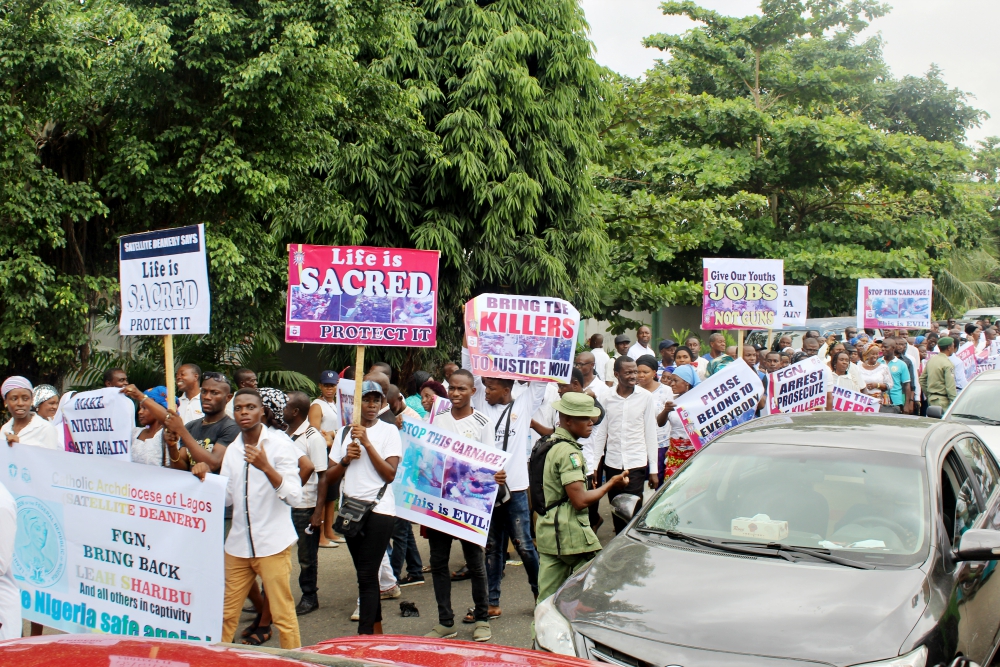 Crowds of people hoist placards, sing hymns and pray the rosary in Lagos May 22 during a peaceful and prayerful protest against recent killings in Nigeria. (Festus Iyorah)