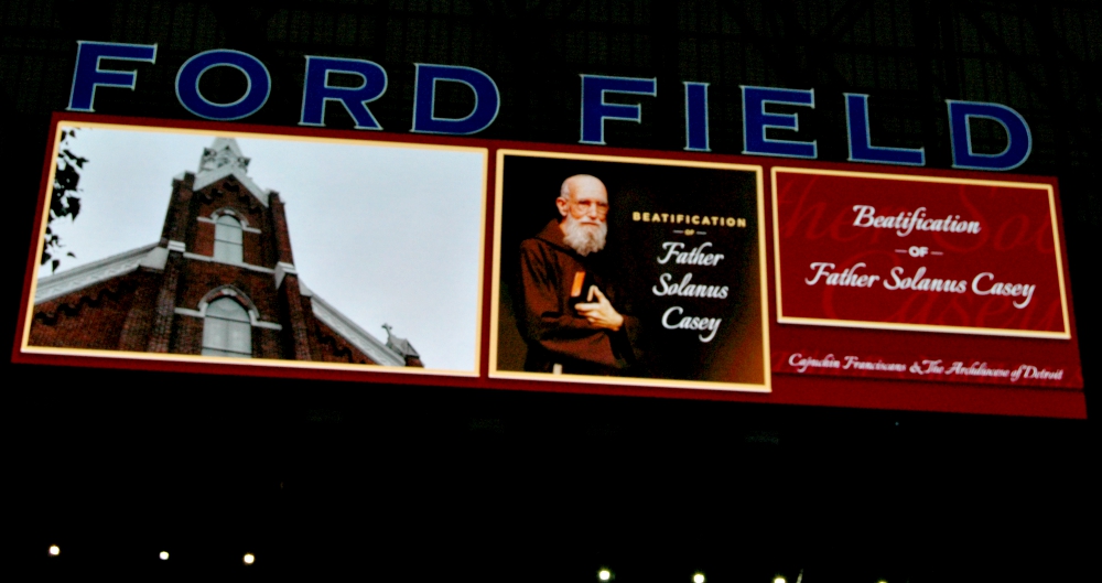 Hung high above Ford Field's end zones, electronic banners celebrate the beatification of Fr. Solanus Casey 60 years after his death. (William E. Odell)