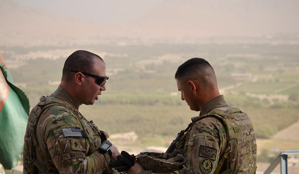 Fr. Christopher Butera, left, prays with Lt. Col. Steven F. Fandrich, squadron commander, in Afghanistan. (Courtesy of Christopher Butera)