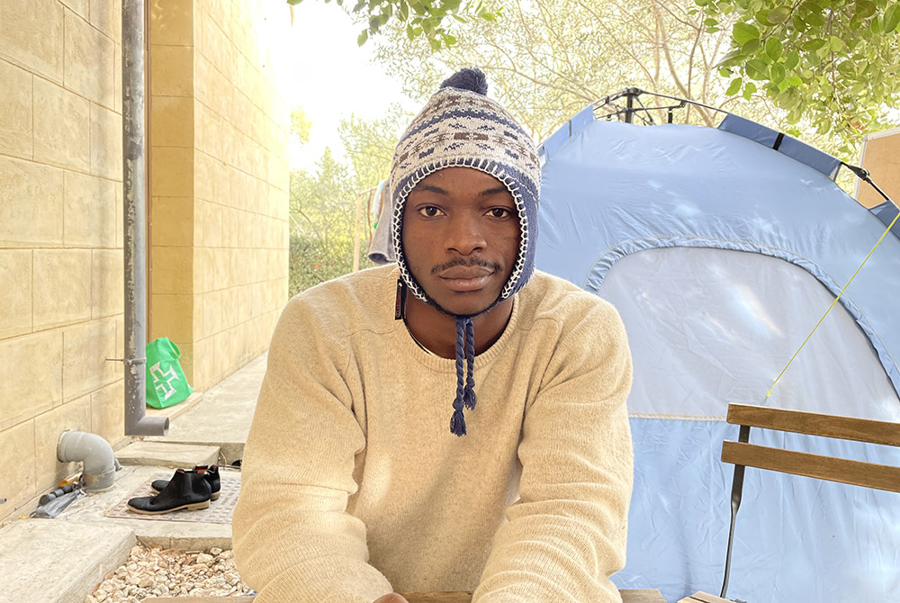 Daniel Ejuba, 20, next to his tent, where he has lived for six-months in "no man's land" in the U.N. controlled buffer zone of Nicosia, Cyprus. (NCR/Christopher White)