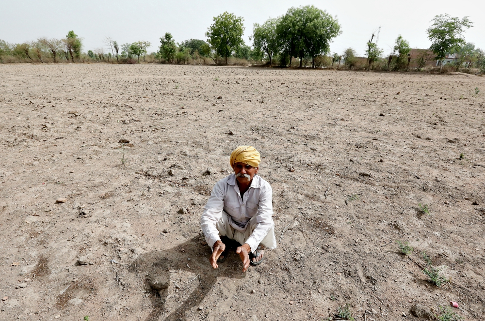 An Indian farmer sits on a dry field in May 2018 outside Chhatarpur. (CNS/EPA/Harish Tyagi)