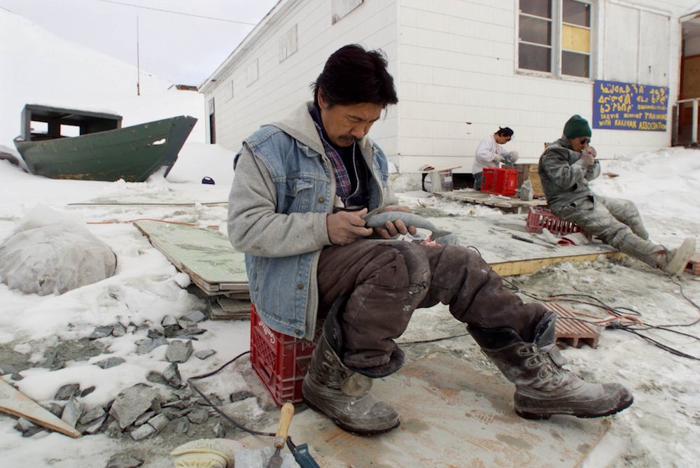 An Inuit carver works on his art on the shore of Frobisher Bay in the Canadian town of Iqaluit, Nunavut. (CNS photo/Shaun Best, Reuters)