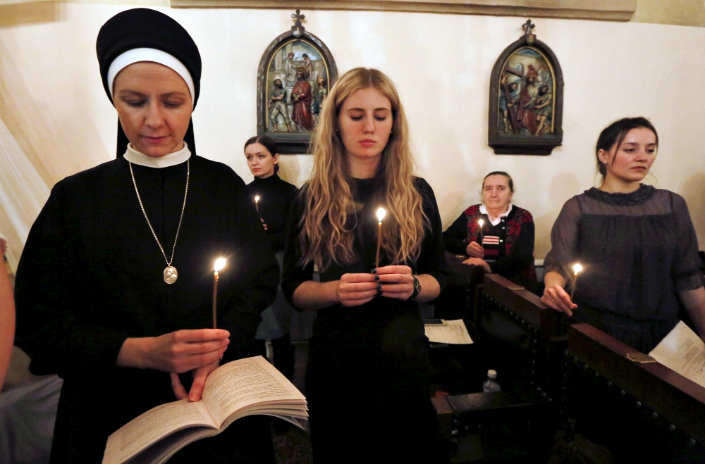 Women hold candles and pray at a Roman Catholic church during the Easter Vigil in Krasnoyarsk, Russia, March 26, 2016. (CNS/Reuters/Ilya Naymushin)