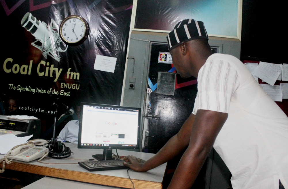 Ekene Odigwe prepares his script for his radio show, "Climate Time." (Patrick Egwu)