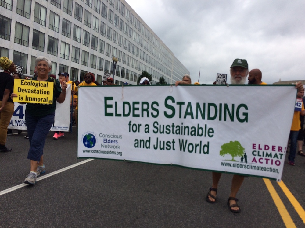Gloria and David Mog carry the Elders Climate Action banner in a Poor People’s Campaign march in Washington, D.C. June 23, 2018. (Provided photo)