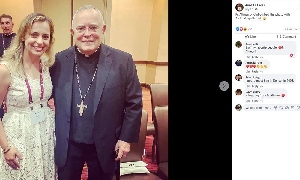 Fr. James Altman appears in the background of a photo as Philadelphia Archbishop Charles Chaput posed with Arina Grossu, one of the organizers of the Jericho March. Grossu posted the photo on Facebook July 26. (NCR screenshot/Facebook)