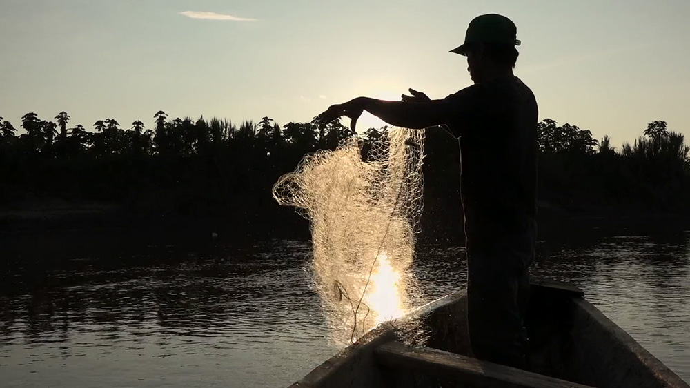 A man tends his fishing net at sundown along the Marañón River in Peru. (Quisca Producciones/M. Araoz)