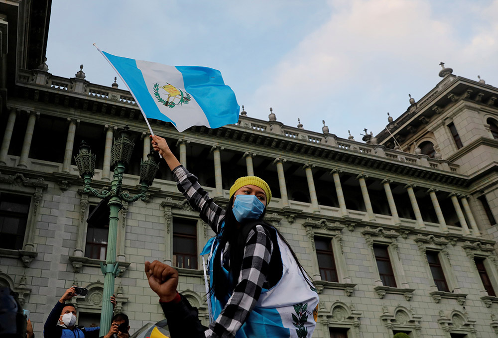 A woman holds up a Guatemalan flag during a protest to demand the resignation of President Alejandro Giammattei in Guatemala City Nov. 22. (CNS/Reuters/Luis Echeverria) A woman holds up a Guatemalan flag during a protest to demand the resignation of President Alejandro Giammattei in Guatemala City Nov. 22. (CNS/Reuters/Luis Echeverria)