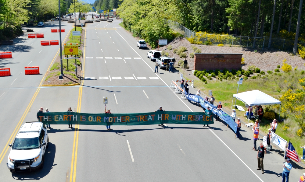 Protesters hold a banner while blocking the Main Gate entrance to Naval Base Kitsap-Bangor May 12 as part of a protest against the Trident submarine base in honor of Mother's Day for Peace. (Ground Zero Center for Nonviolent Action/Glen Milner) Protesters hold a banner while blocking the Main Gate entrance to Naval Base Kitsap-Bangor May 12 as part of a protest against the Trident submarine base in honor of Mother's Day for Peace. (Ground Zero Center for Nonviolent Action/Glen Milner)