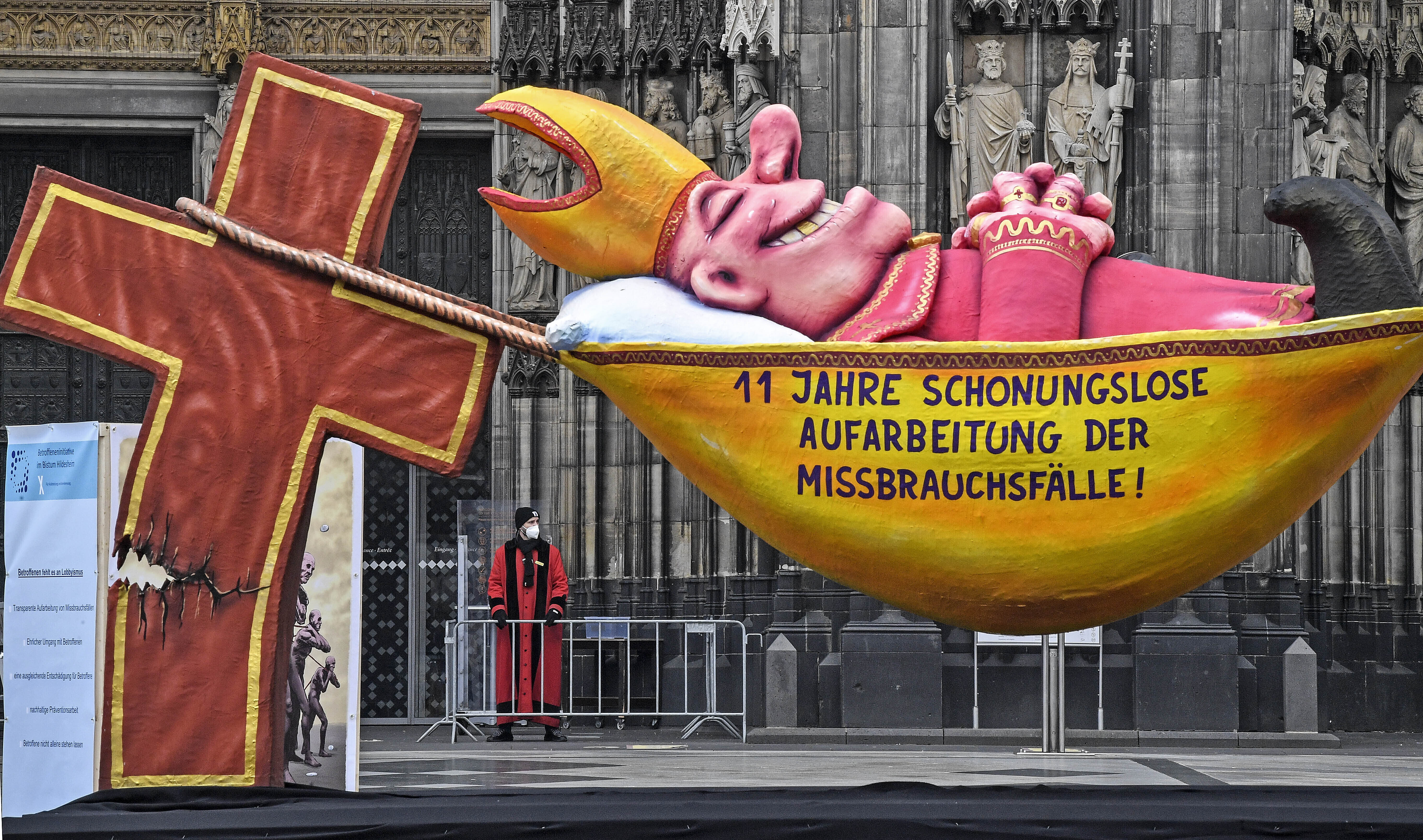 A carnival float depicting a sleeping Cardinal, reading '11 years of relentless processing of cases of abuse' is set in front of the Cologne Cathedral to protest against the Catholic Church in Cologne, Germany, Thursday, March 18, 2021. (AP Photo/Martin M A carnival float depicting a sleeping Cardinal, reading '11 years of relentless processing of cases of abuse' is set in front of the Cologne Cathedral to protest against the Catholic Church in Cologne, Germany, Thursday, March 18, 2021. (AP Photo/Martin M