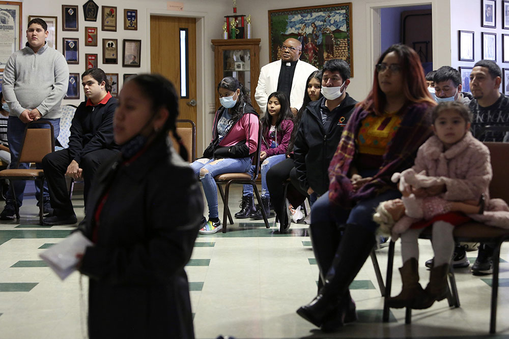 Fr. Athanasius Abanulo stands behind a group of parishioners as they hold a special ceremony for the Lady of Guadalupe at Holy Family Catholic Church in Lanett, Alabama, on Dec. 12, 2021. (AP/Jessie Wardarski)