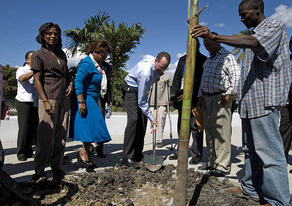 On Jan. 10, 2012, Dr. Paul Farmer, center, plants a palm tree during the inauguration of a national referral and teaching hospital in Mirebalais, 30 miles north of Port-au-Prince, Haiti. (AP/Dieu Nalio Chery)