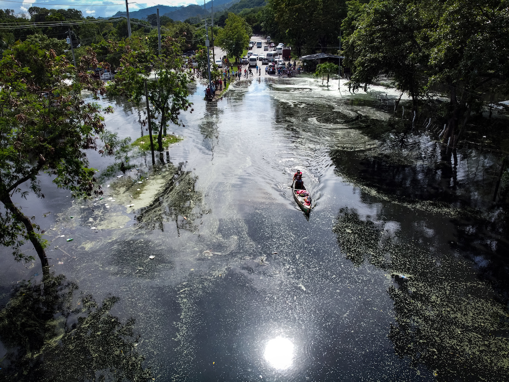 A boat navigates along the main highway between San Pedro Sula and the port of Puerto Cortés in Honduras after the road was flooded by rain from hurricanes Eta and Iota. (Photo courtesy of Sean Hawkey, World Council of Churches)