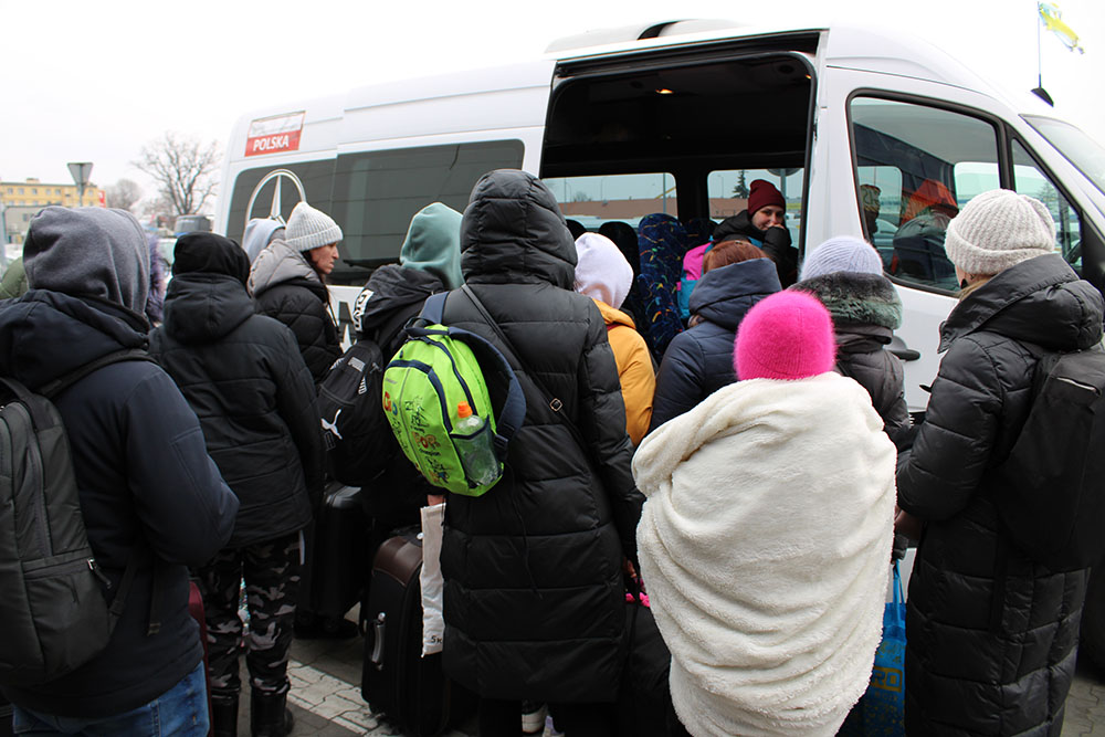 Ukrainian refugees at refugee reception center in Przemyśl, Poland, board a van taking them to buses or other transport and ultimately to their final destinations in Poland or other European countries. (NCR photo/Chris Herlinger)