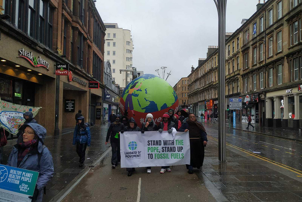 Catholics take part in a march of more than 100,000 people Nov. 6 through the streets of Glasgow, Scotland, calling for stronger and more urgent action to address climate change from world leaders. (Laudato Si' Movement)