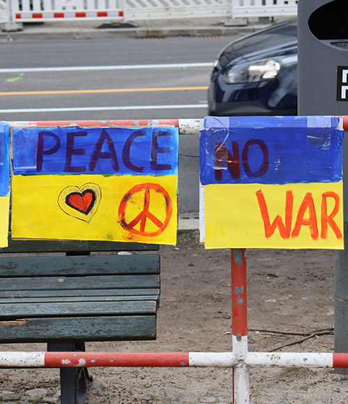 Signs painted in the colors of the Ukraine flag call for peace outside the Russian Embassy in Berlin March 4. (NCR photo/Teresa Malcolm)