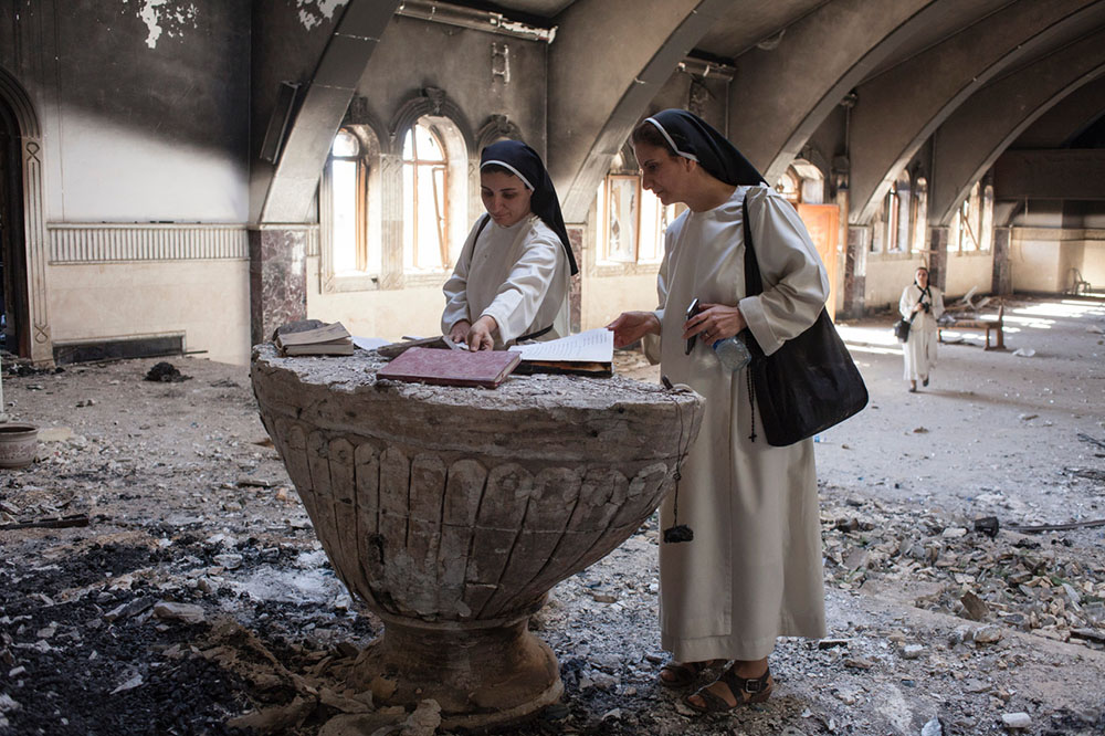 Dominican Srs. Luma Khudher and Nazik Matty inside Al-Tahera Cathedral in Mosul, Iraq, in November 2016, a few days after Qaraqosh was liberated from Islamic State control (NCR photo/Eugenio Grosso)