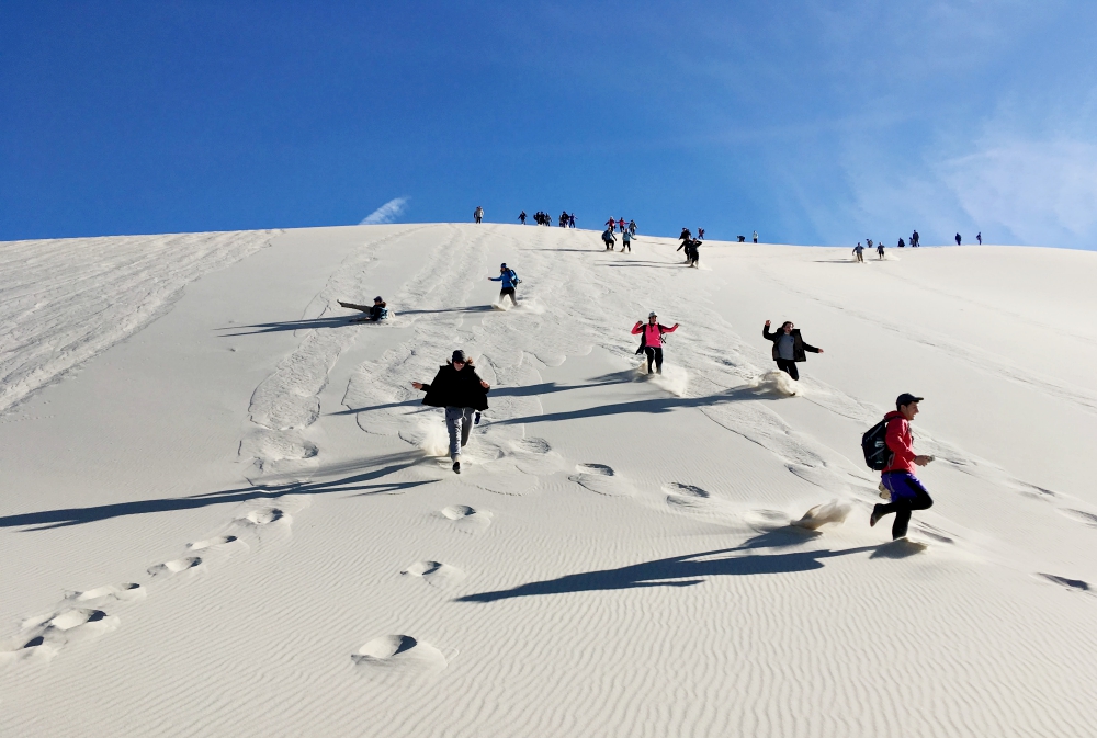 University of Scranton Students enjoy descending Eureka Dunes at the end of the day in Death Valley National Park on A Desert Experience Retreat. (Fred T. Mercadante)