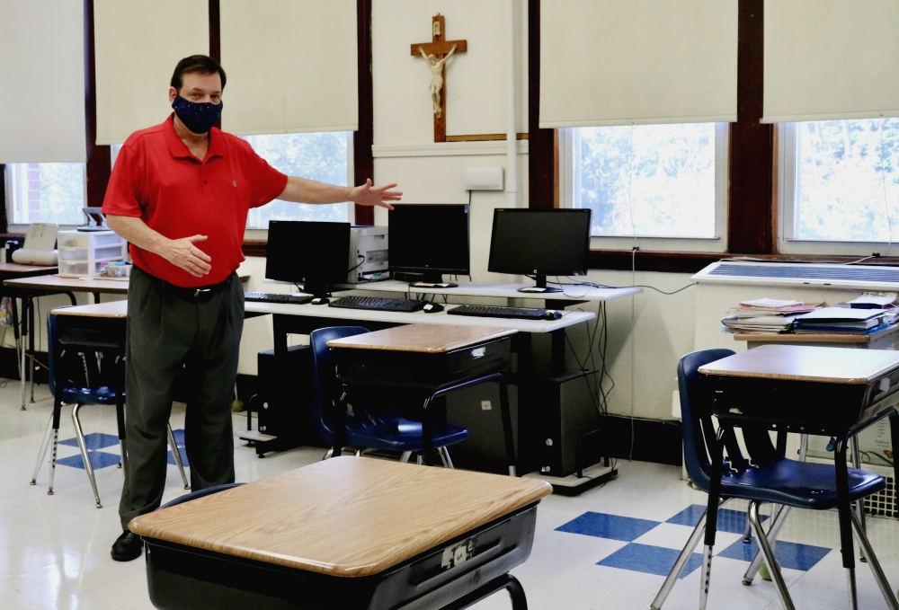 Principal Robert Chevrier shows off a socially distanced sixth-grade classroom at St. Joseph School in Medford, Massachusetts, July 28. Soon the desks will all have plastic dividers as well. (Alexander Thompson)