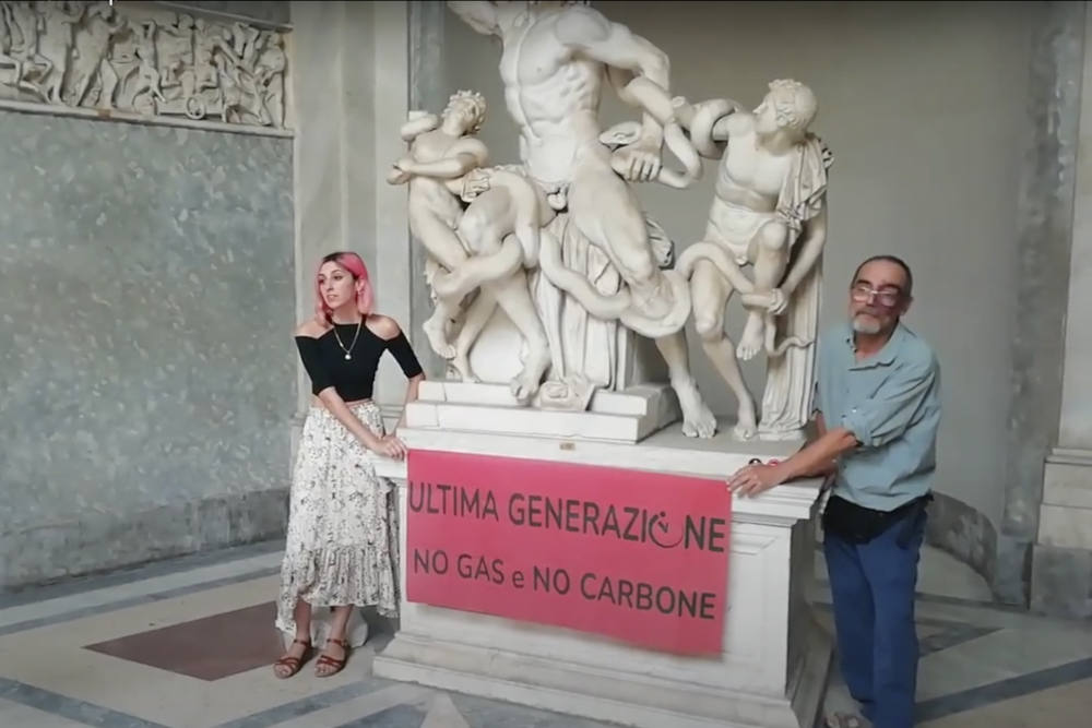 A video grab from footage made available by environmental activists shows two members of Ultima Generazione glued their hands on the Roman statue of Laocoön and His Sons at the Vatican Museums to protest climate change. (Ultima Generazione Via AP)
